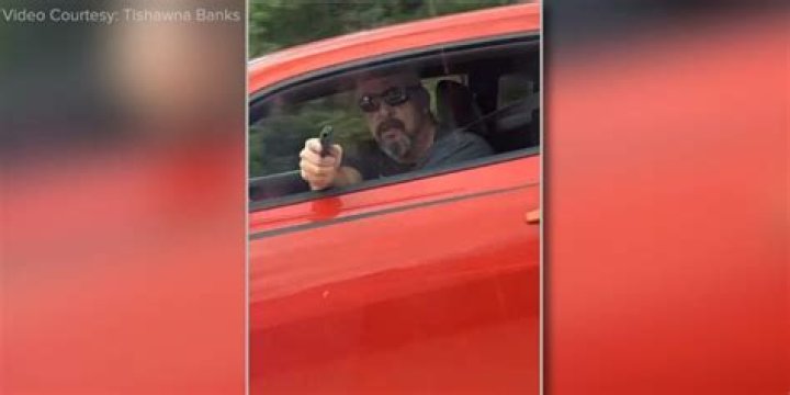 Wife defends husband allegedly seen in video pointing gun at fellow driver